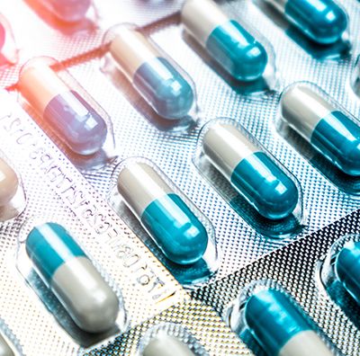 Long blue and white pills individually sealed in foil packs.