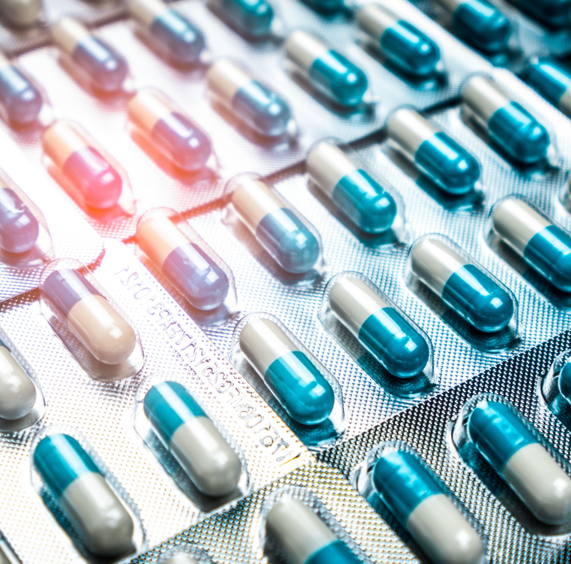 Long blue and white pills individually sealed in foil packs. 