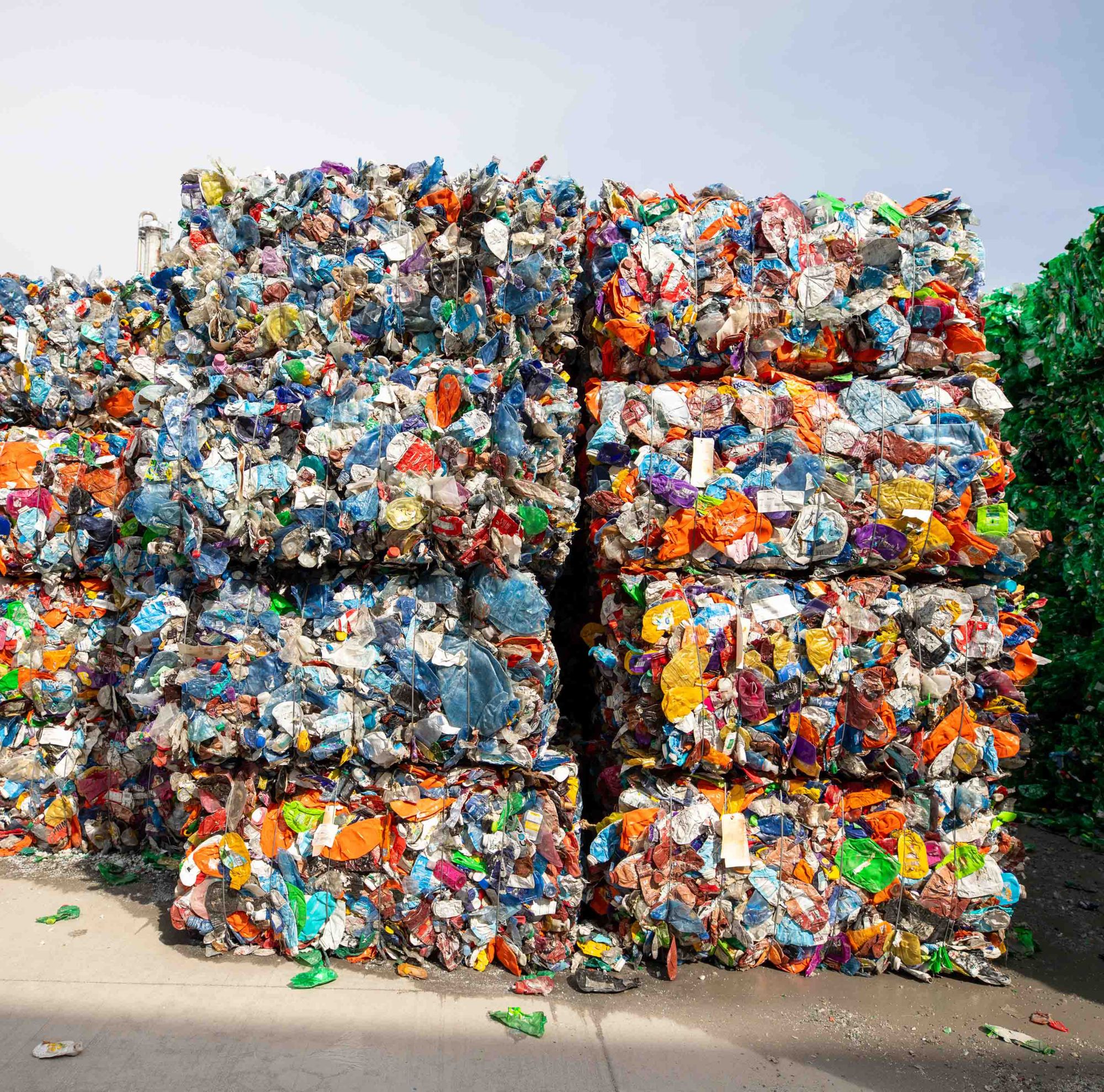 Large bales of stacked, mixed plastic waste. 