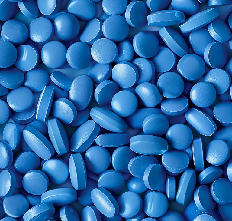 Dozens of blue pills in a pile. 