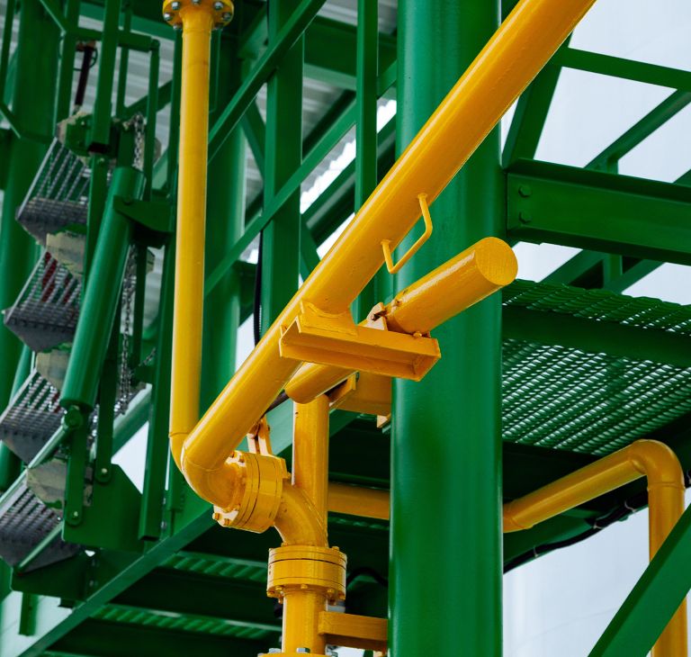Pipes covered with green and yellow protective paint. 