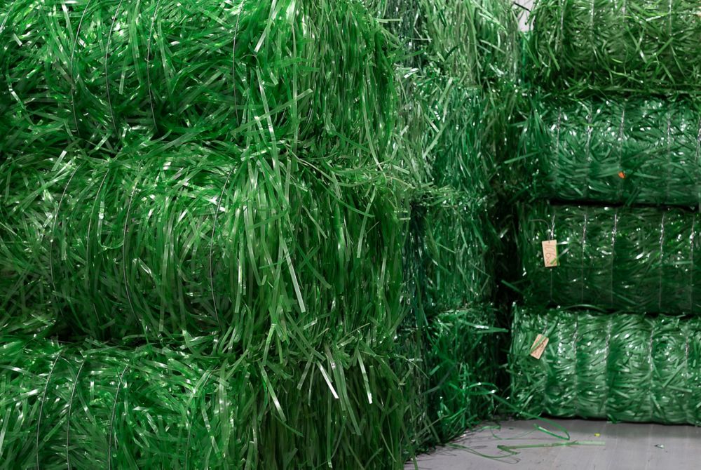 Piles of bundled PET plastic strapping used as feedstock in a recycling plant. 