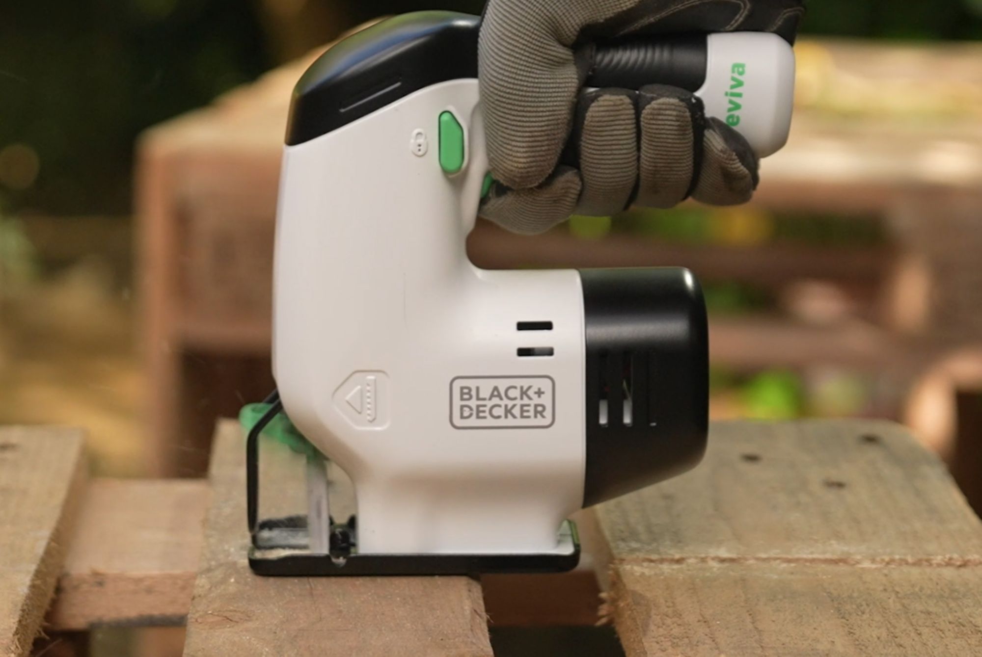 A person using the reviva Black and Decker jigsaw to cut a wood pallet. 
