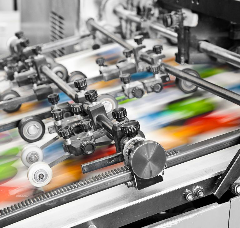 A printer sprays various colors of ink on paper. 