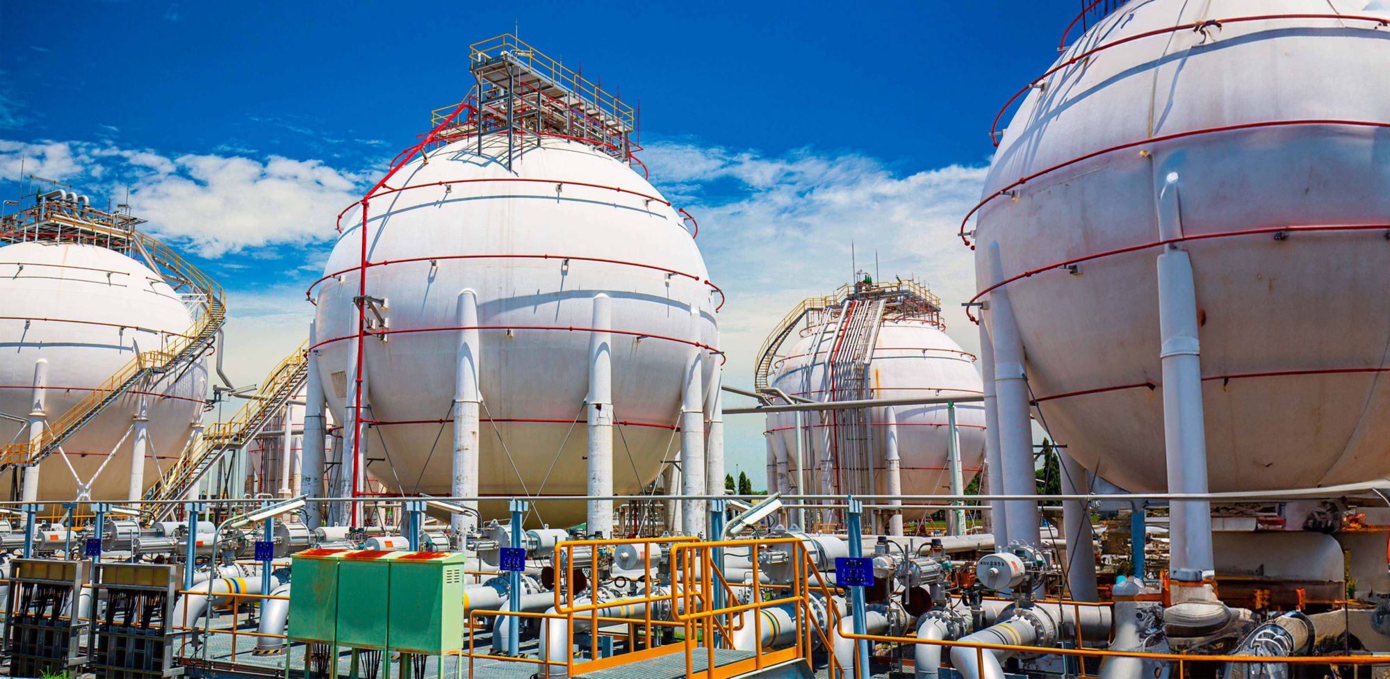Large white spherical propane tanks storing fuel outdoors. 