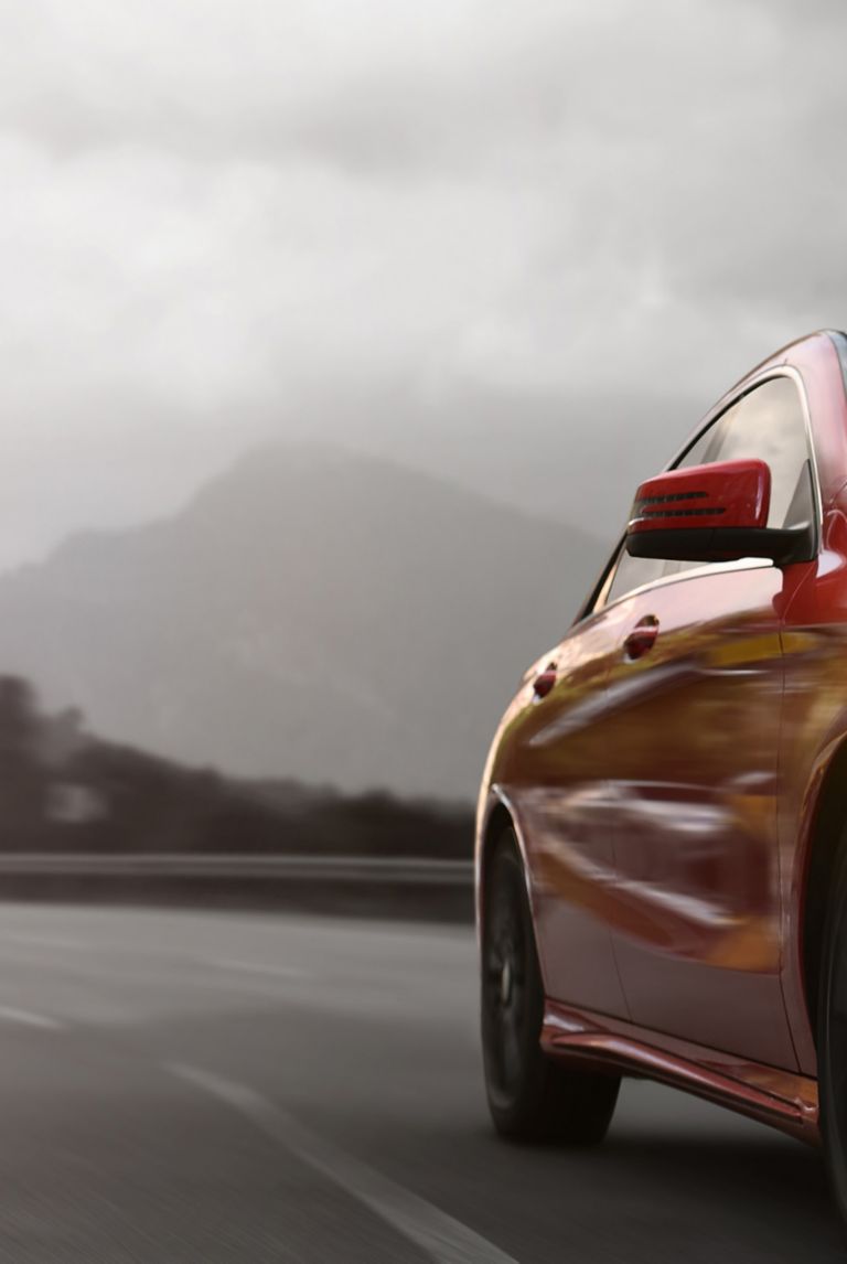 Red business car speeding on a mountain highway 