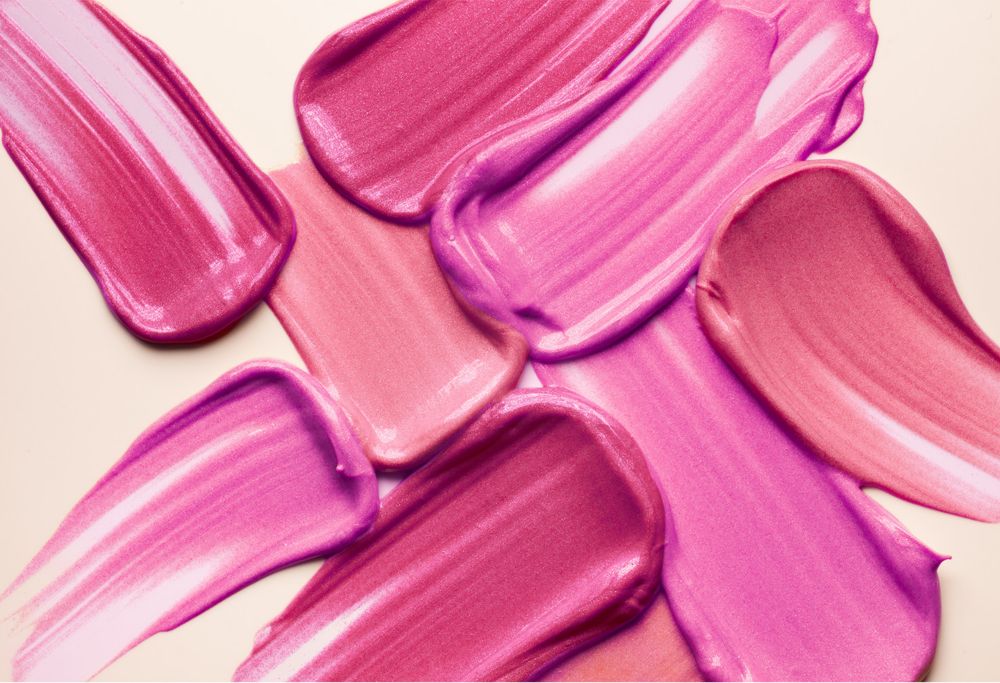 Swatches of shimmery pink and purple lip gloss.   