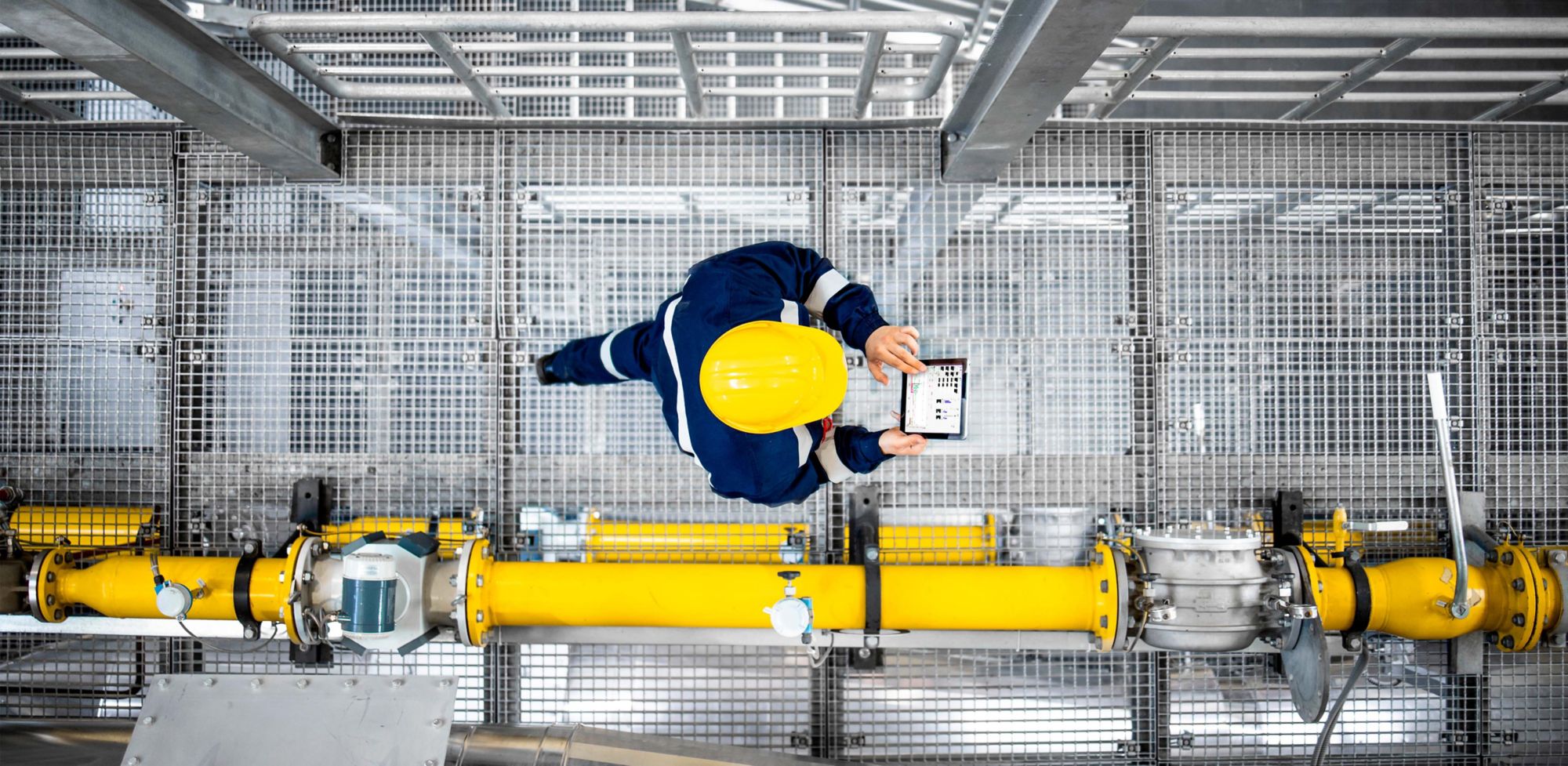 Aerial view of a refinery worker checking production plant data.   