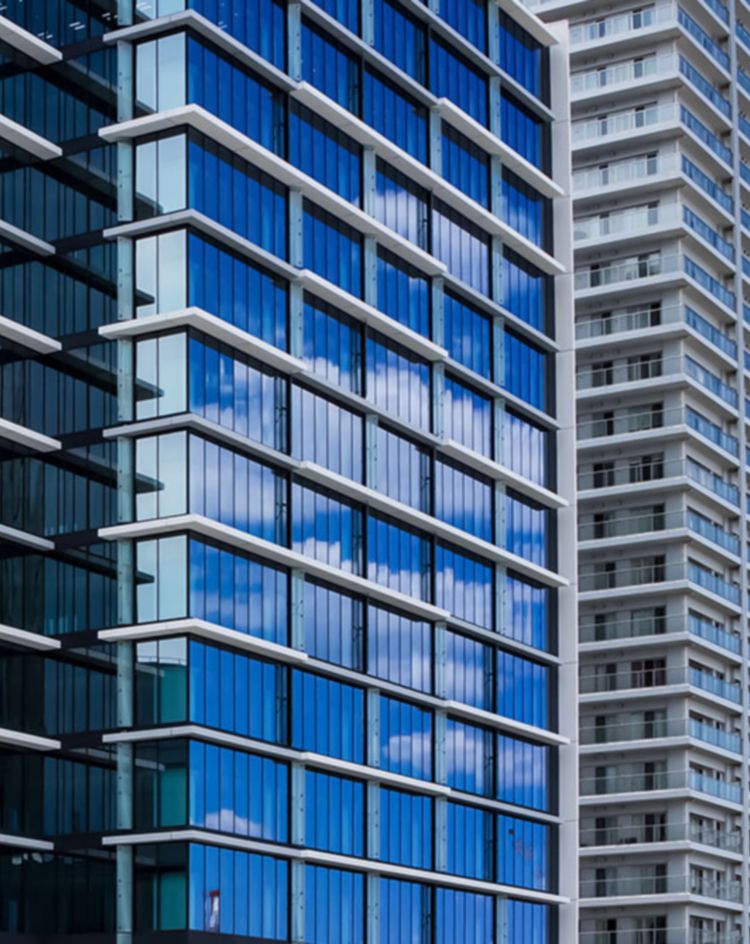 Tall modern building with blue‑tinted glass windows. 