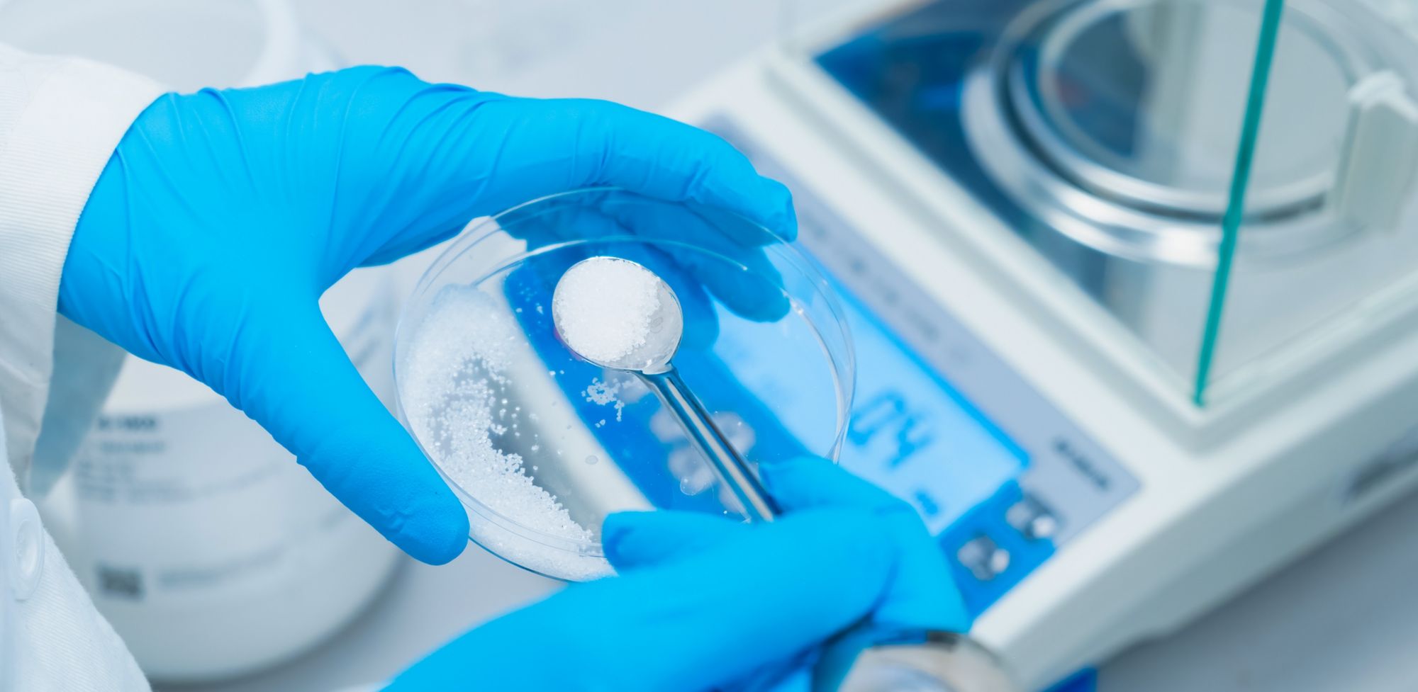 A scientist weighing white powder. 
