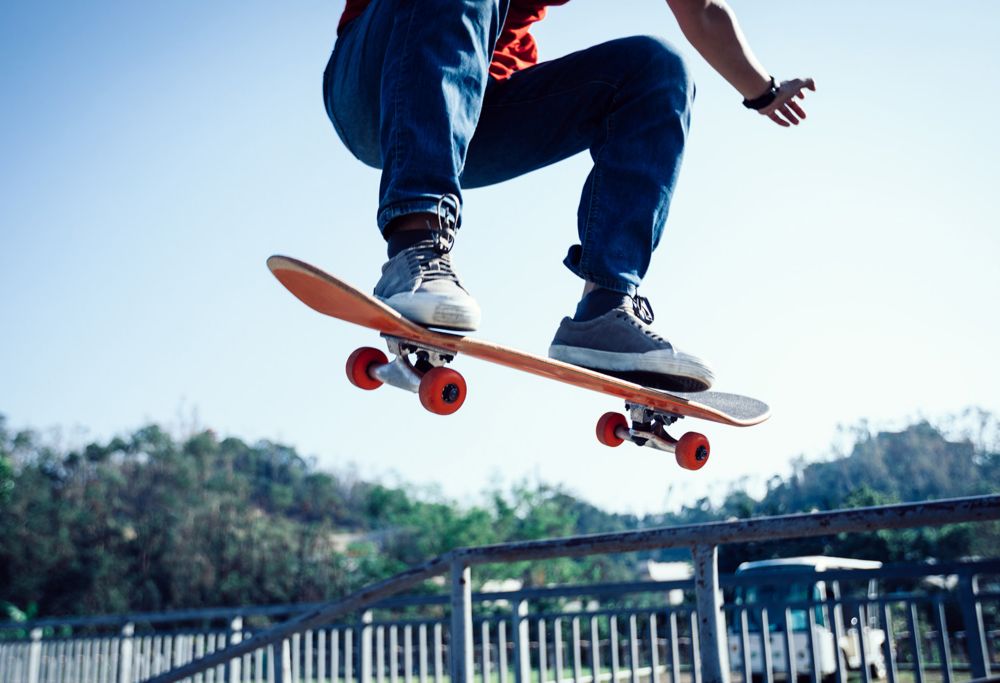 A person jumps while riding a skateboard. 