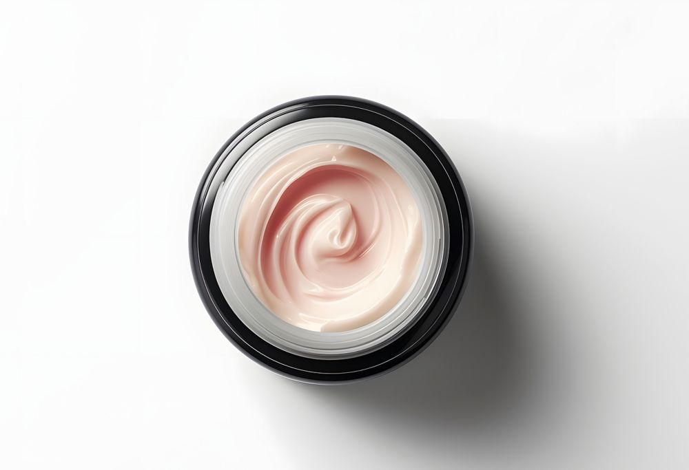 The inside of a jar of cream skin care, with the product swirled in the center.   