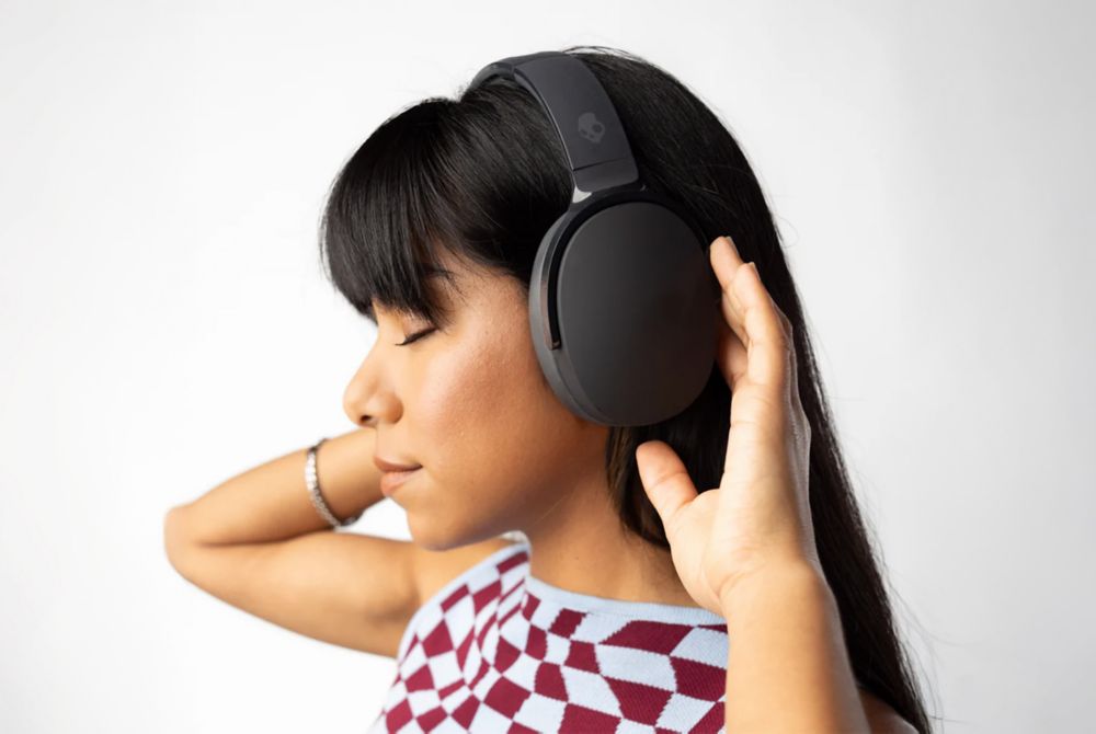  A person wears over-the-ear Skullcandy headphones. 