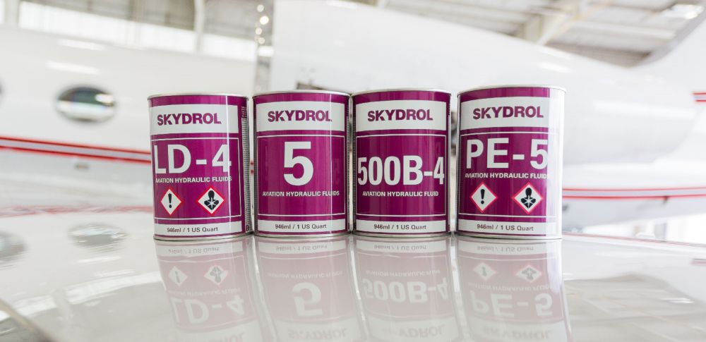 Four cans of Skydrol aviation hydraulic fluids on an airplane wing 