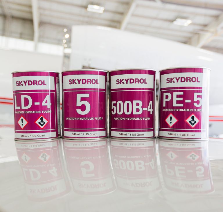 Four Skydrol cans sit in a row. 