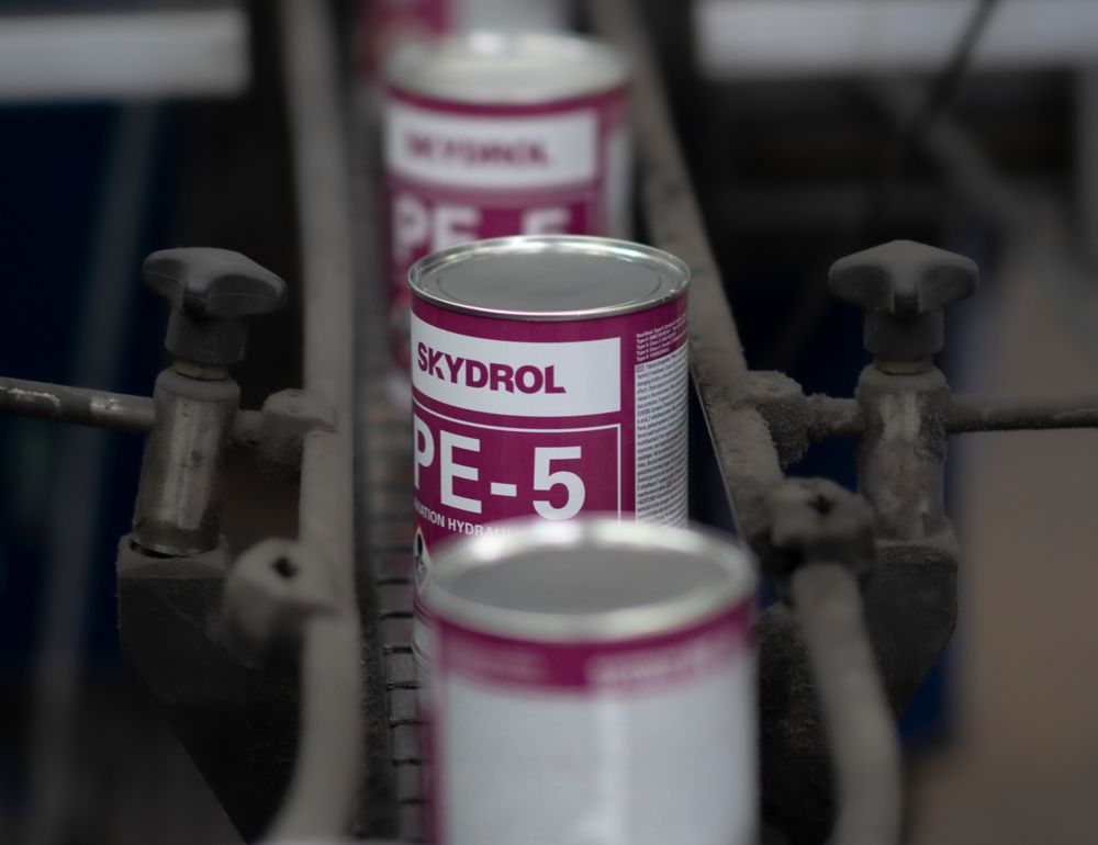 Skydrol cans come down a belt on a production line. 