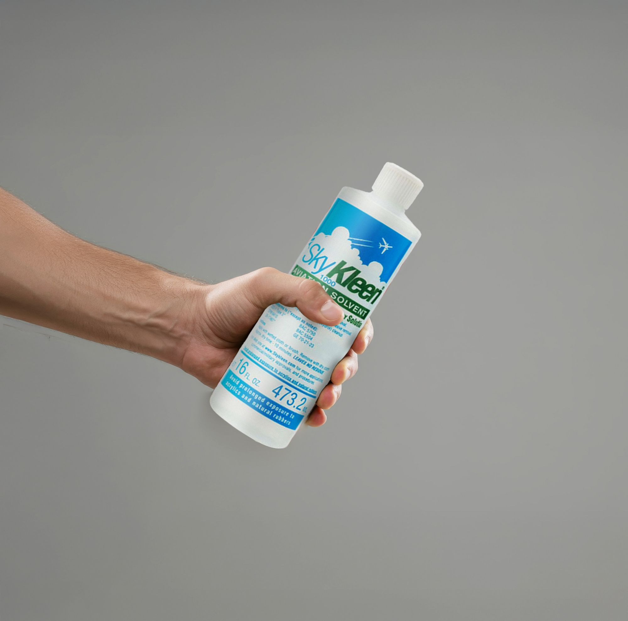 A person holds a SkyKleen bottle. 