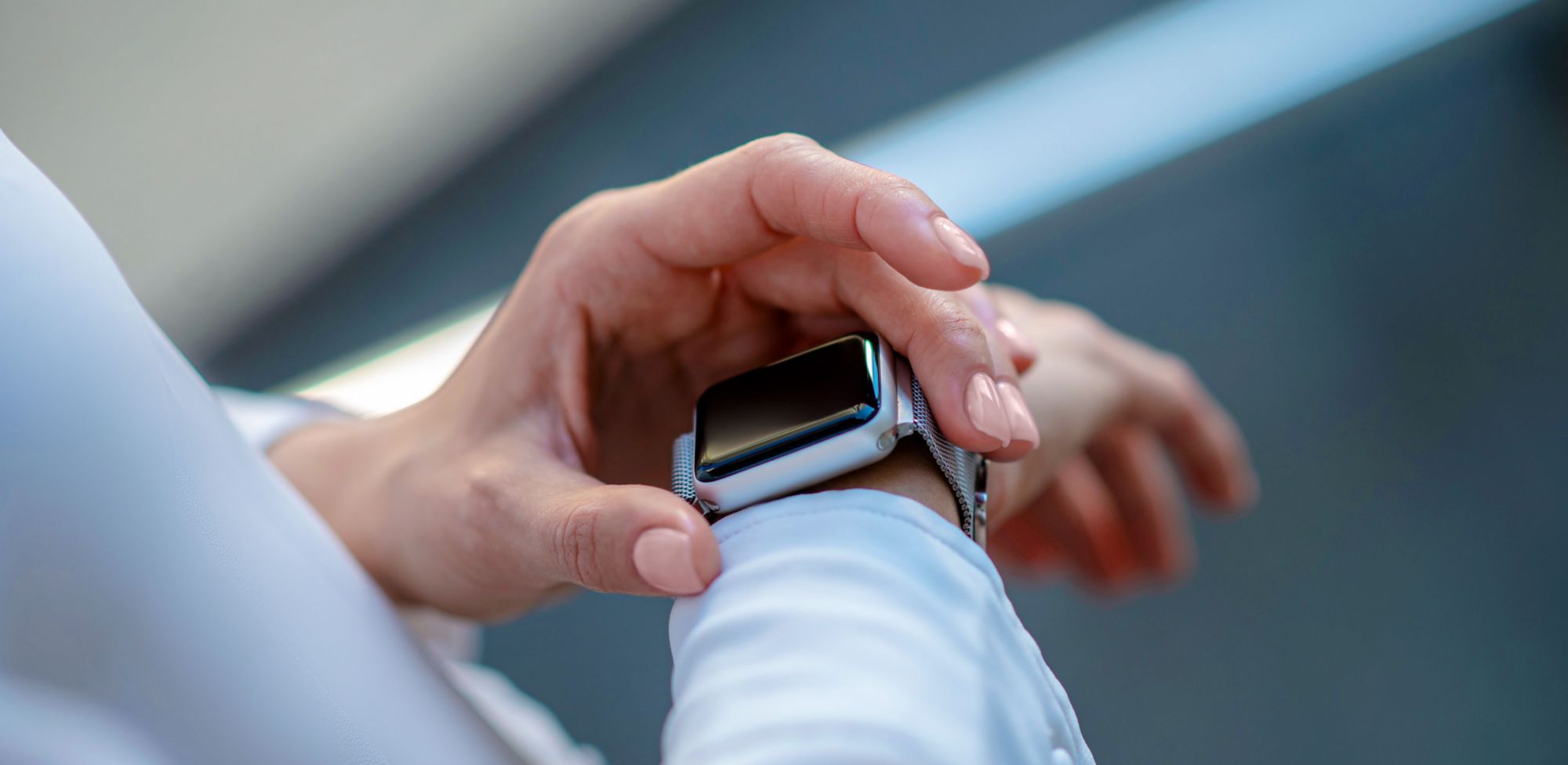 Close-up of a person's hand touching a smartwatch.  