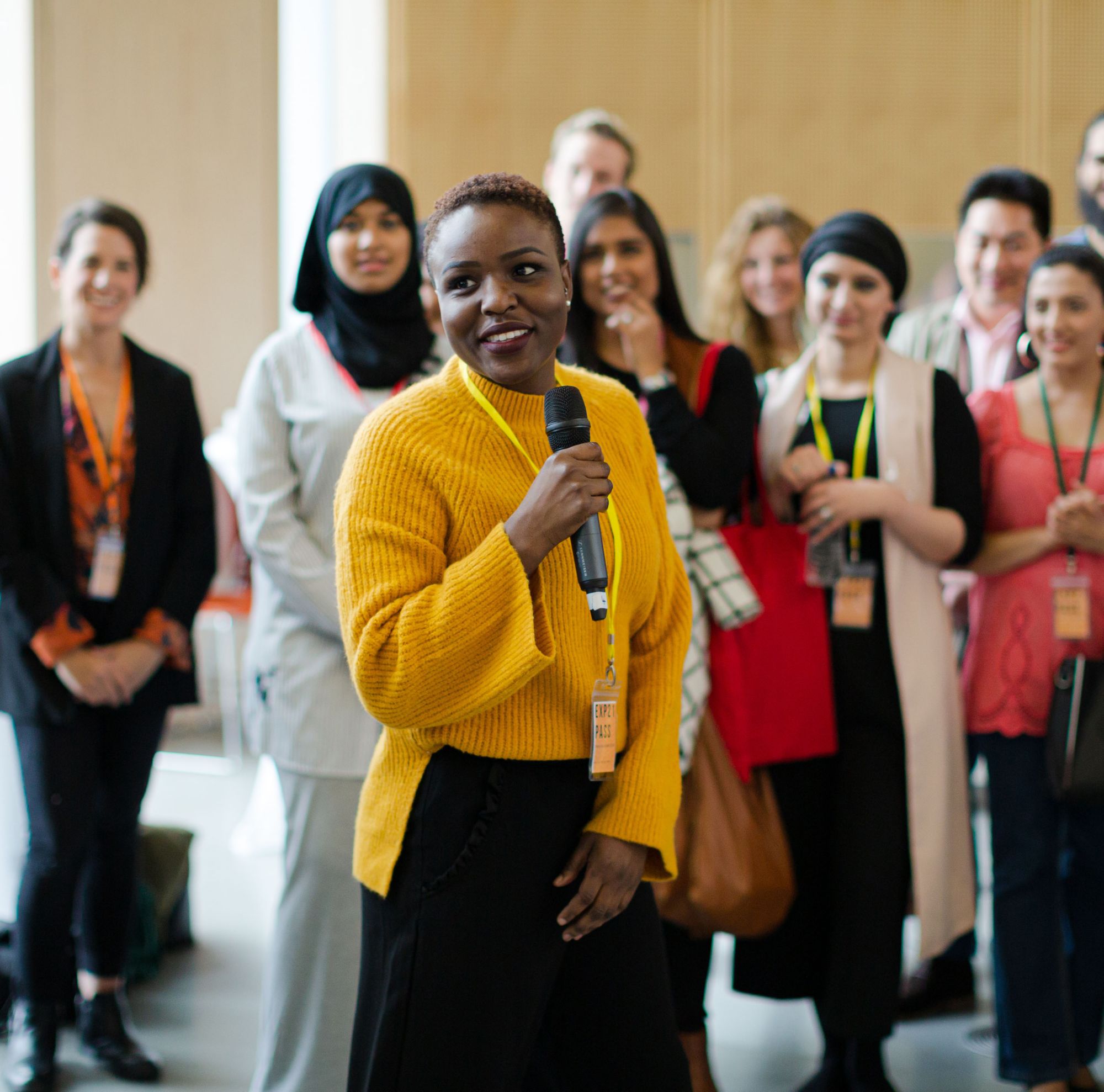 Speaker holding a microphone in front of crowd. 