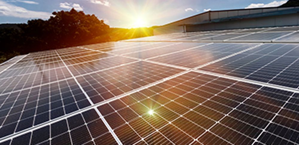 Photovoltaic solar panels on a factory roof absorb sunlight as a source of electrical energy 