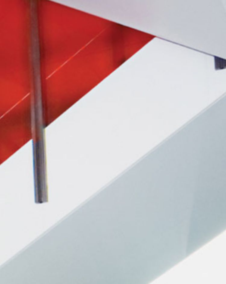 Interior staircase with bright red glass panel railings. 