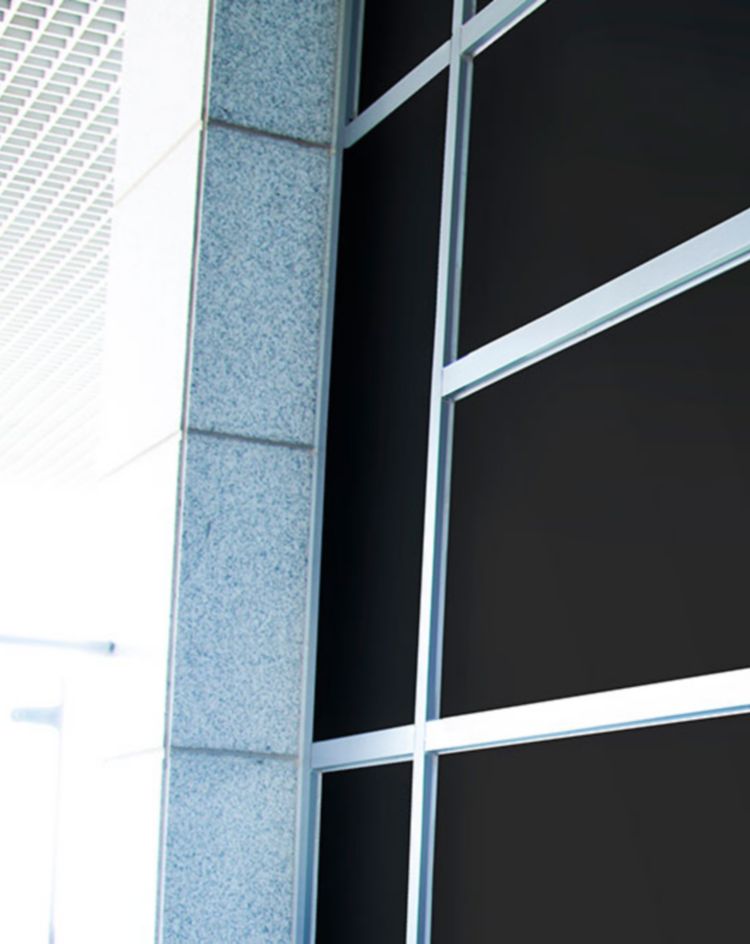 Glass storefront covered with black opaque film displaying the text ‘Coming Soon!’ in white script lettering near the door handle. 