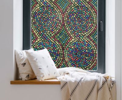 Cozy, private window nook showing the installed Spiral Mosaic film behind throw pillows.