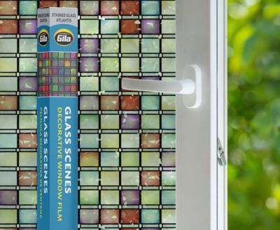 Retail packaging displayed next to a window treated with the Stained Glass Atlantis decorative film.