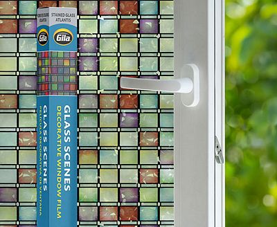 Retail packaging displayed next to a window treated with the Stained Glass Atlantis decorative film.