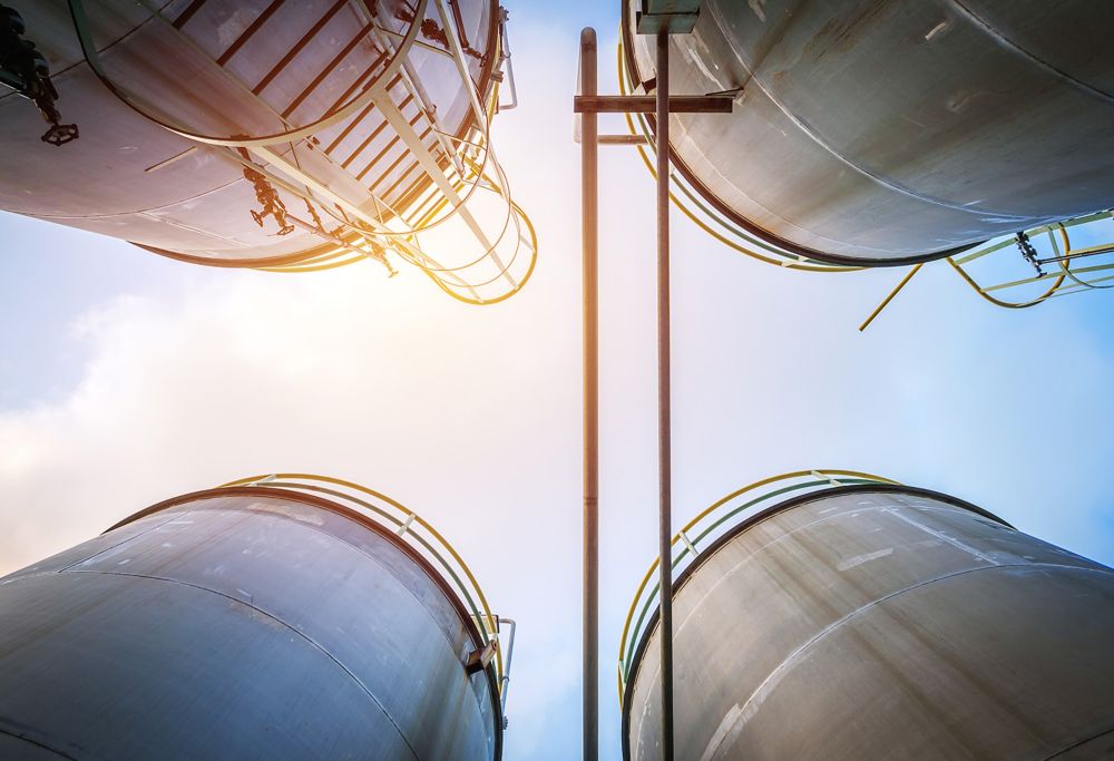 Four exterior storage tanks are seen from the ground looking up 