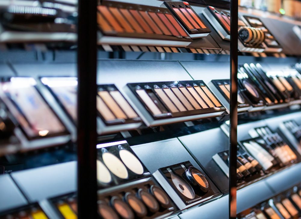 Open powders and eye shadow compacts on display in a store. 