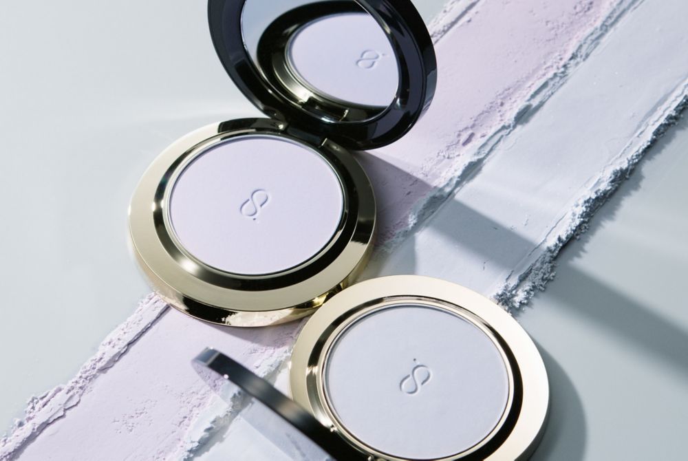 A SUQQU setting powder compact, featuring a glossy finish and small brush.    