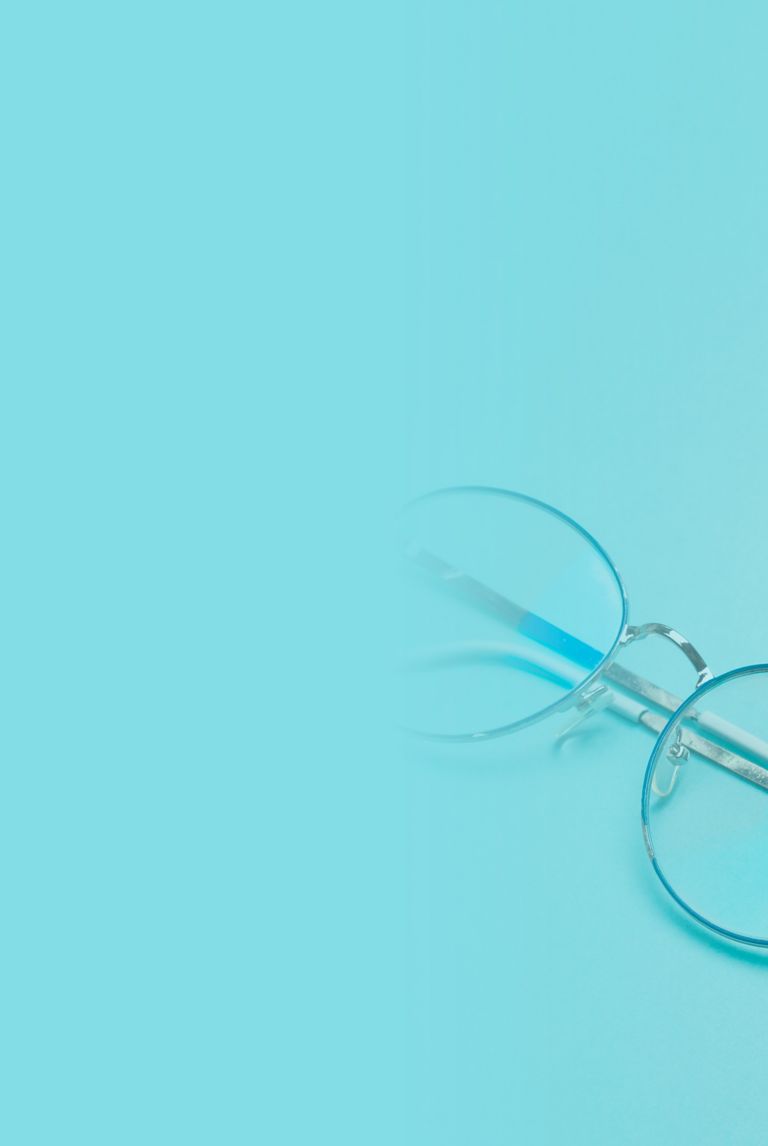 Metal wire glasses resting on a light-blue surface. 