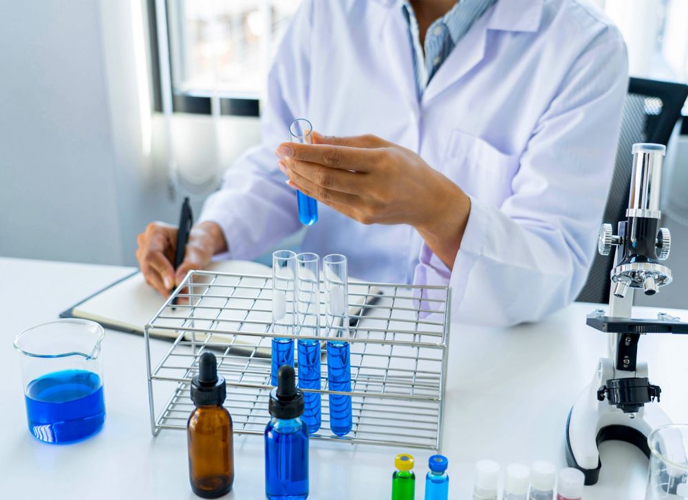 A scientist analyzing a test tube half-filled with blue liquid. 