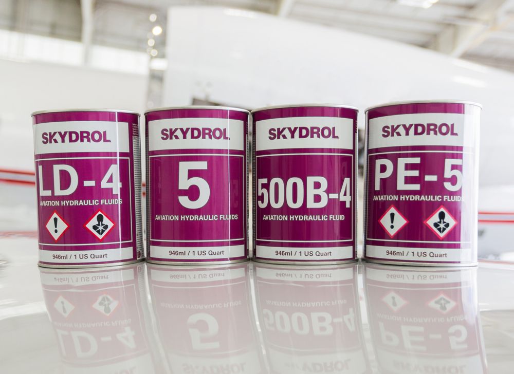 Four Skydrol cans sit on a surface. 