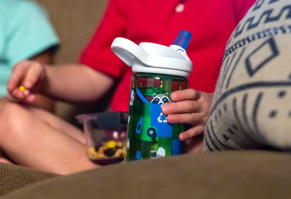 A toddler holds a raccoon-designed sippy cup made with Tritan. 
