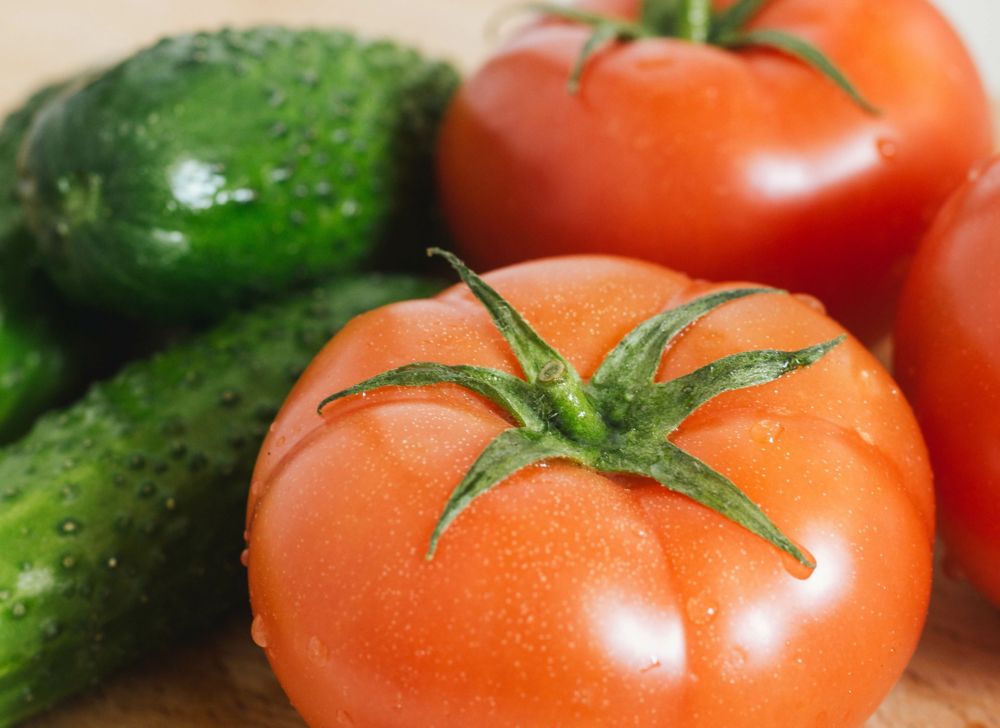 Freshly cleaned ripe tomatoes and cucumbers 