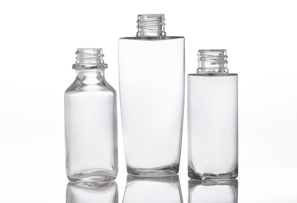 Three clear cosmetic bottles made from Eastman Cristal lined up. 