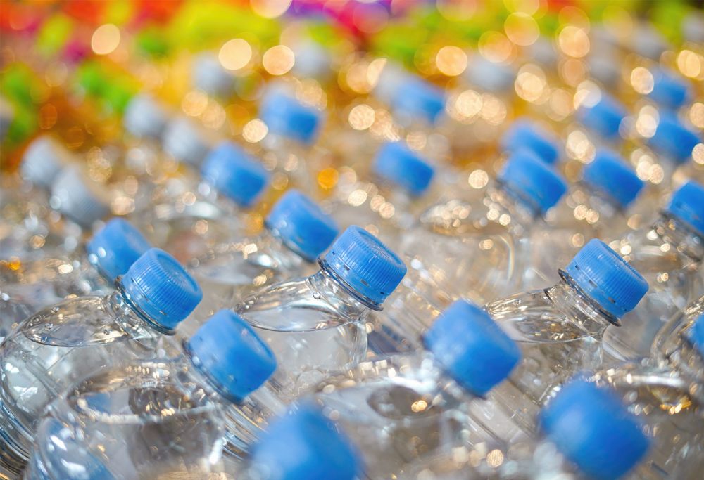 An array of water bottles with different colored caps. 