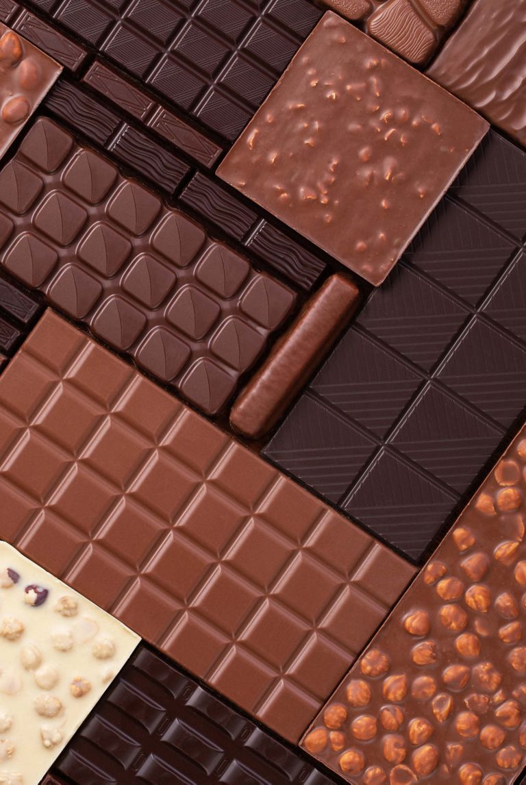 An array of white, dark and milk chocolates arranged in a pattern.  