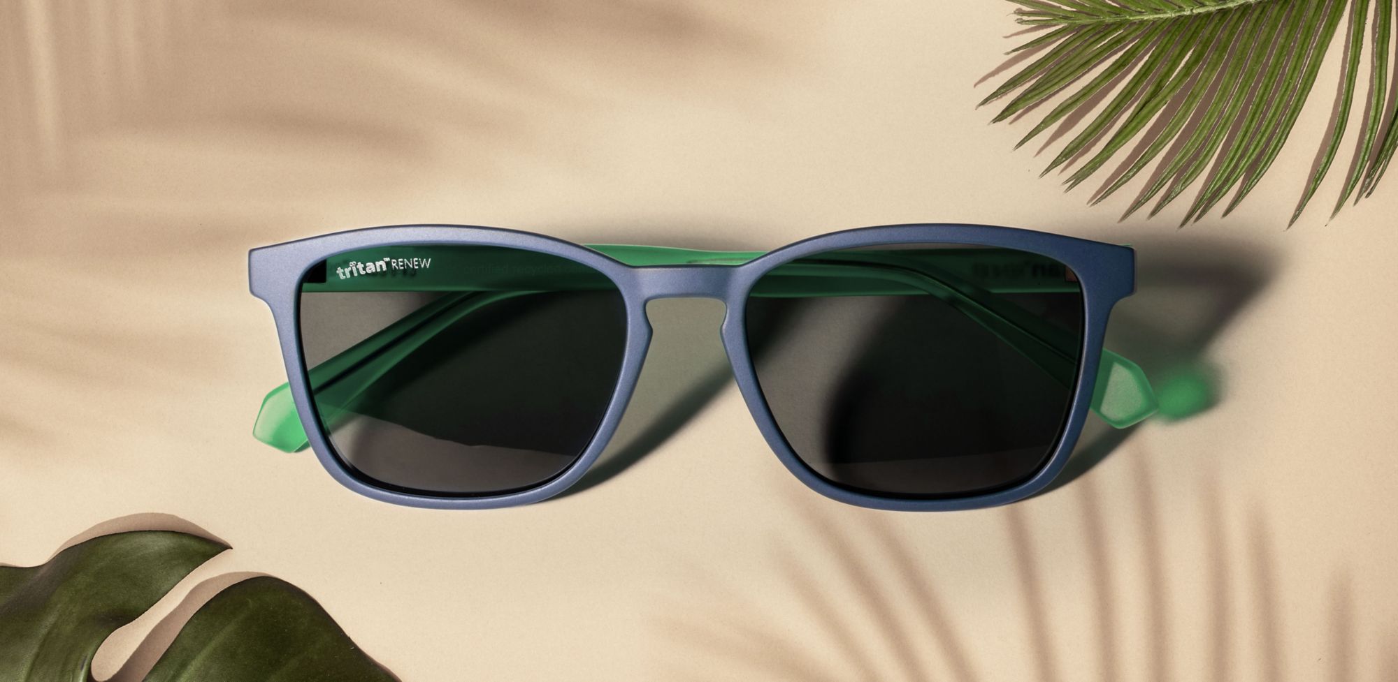 Flat lay of light blue sunglasses made with Tritan Renew material. 