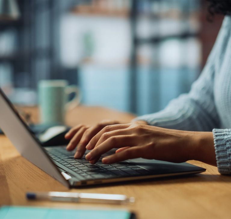 A person types on a laptop keyboard. 
