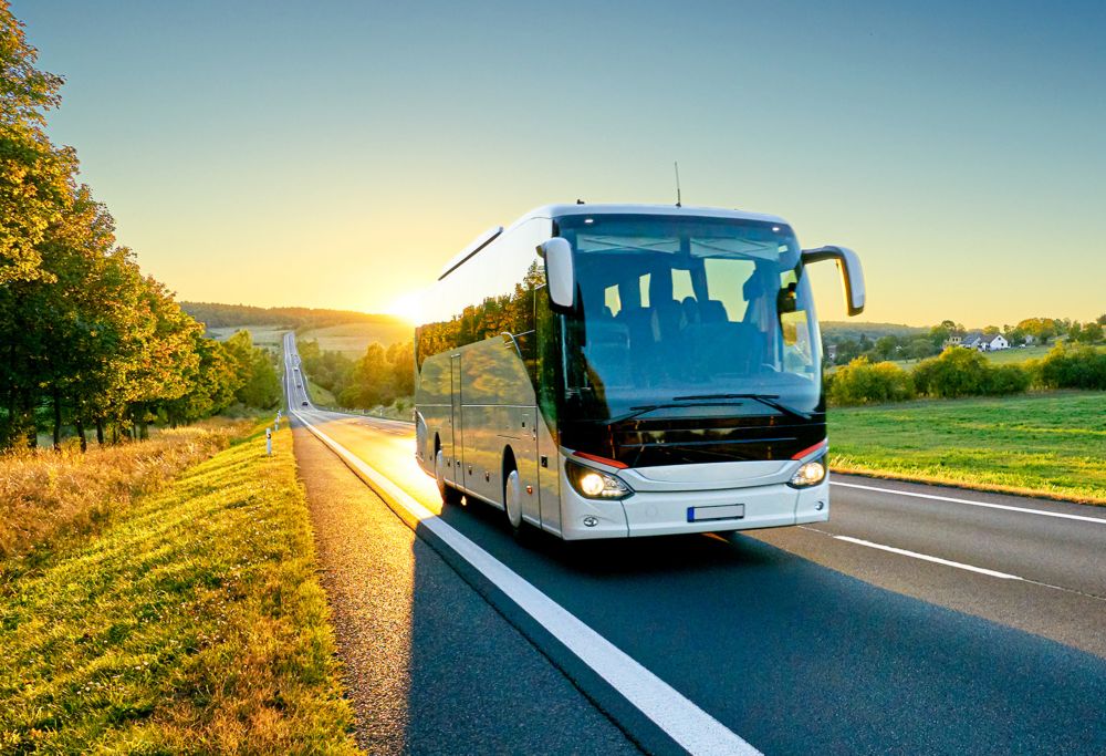 Tour bus on the road during sunset. 