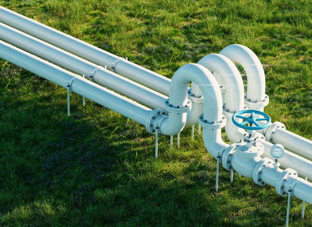 Landscape view of three white gas pipelines. 