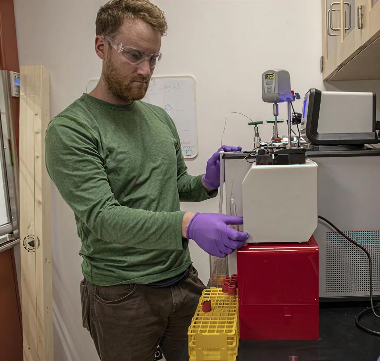 A WHOI researcher conducts a seawater test in a lab. 