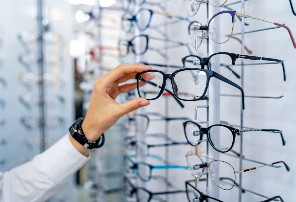A person selecting eyeglasses from a display. 