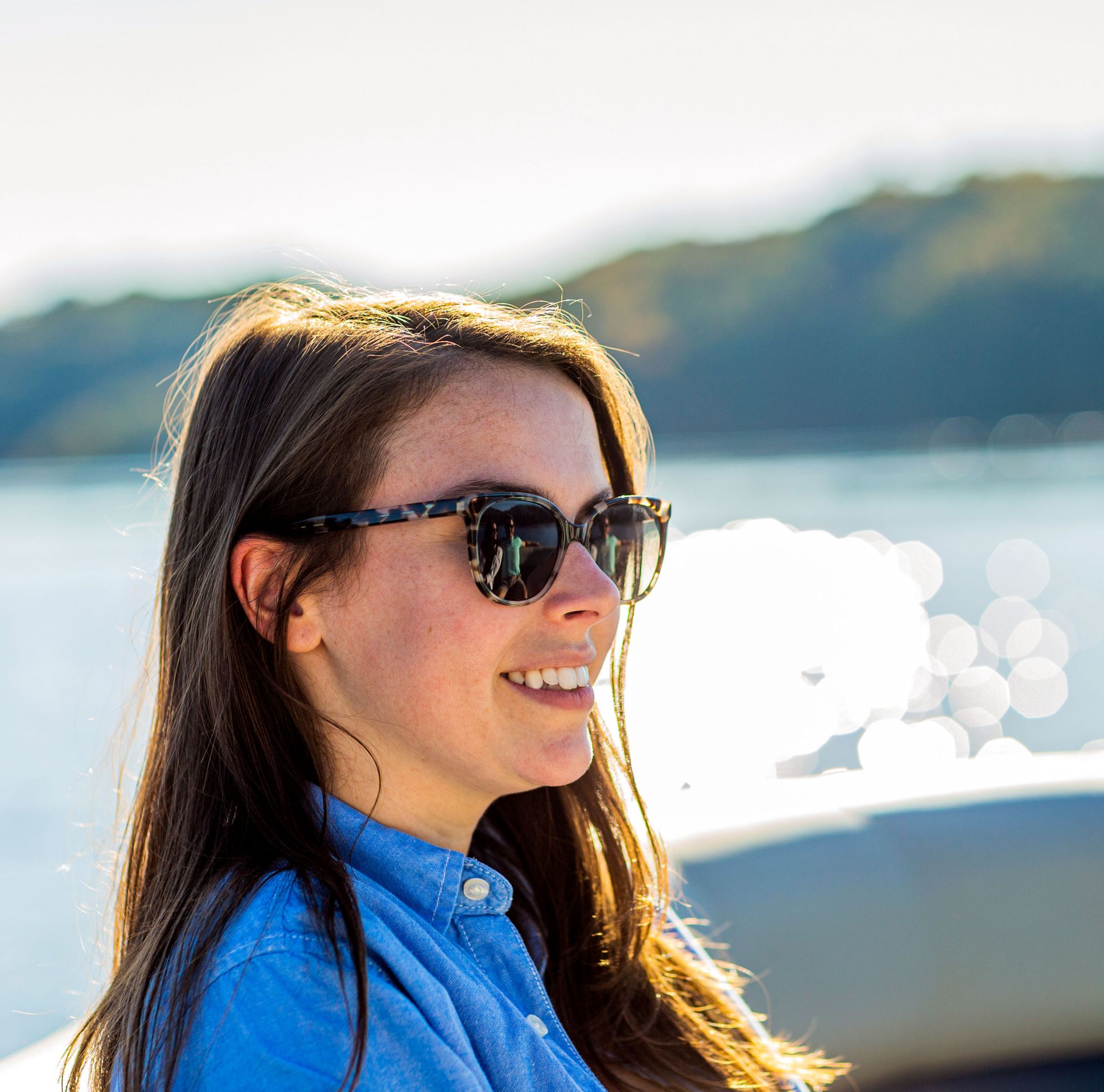 A woman sitting in a boat wearing sunglasses. 