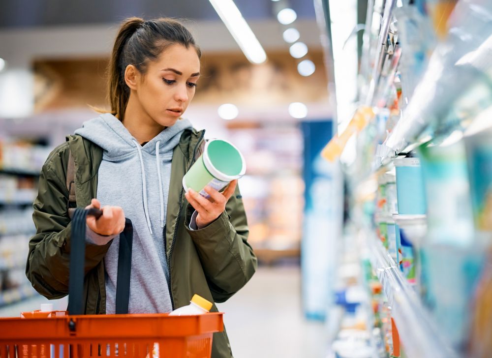 A woman reads food labels in a grocery store. 