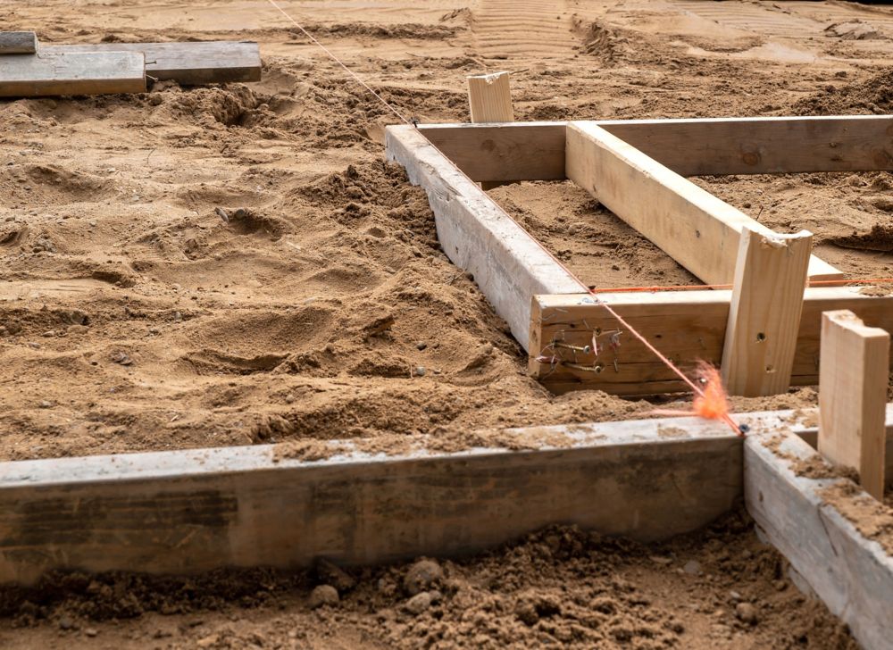 Wooden markers are placed in dirt at a construction site.  