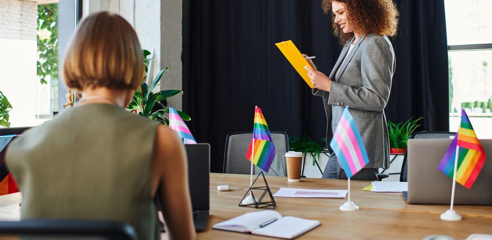 Conference room with LGBTQ flags on the table.